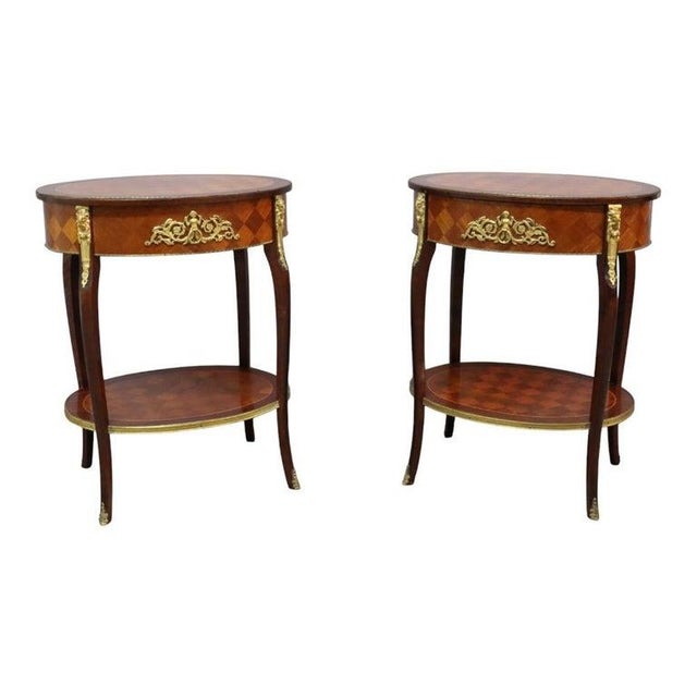 A distinguished pair of antique Louis XV style oval side tables, crafted from rich rosewood with intricate parquetry...