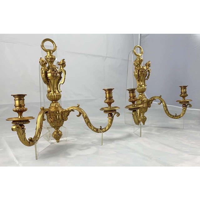 A fine pair of ormolu two branch wall light, circa 1900. Each with cast foliate decoration applied with classical figures....
