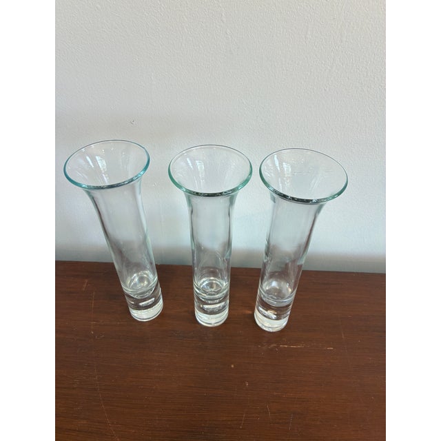 A set of three vintage controlled bubble glass bud vases featuring clean, flared silhouettes and distinctive bubble...