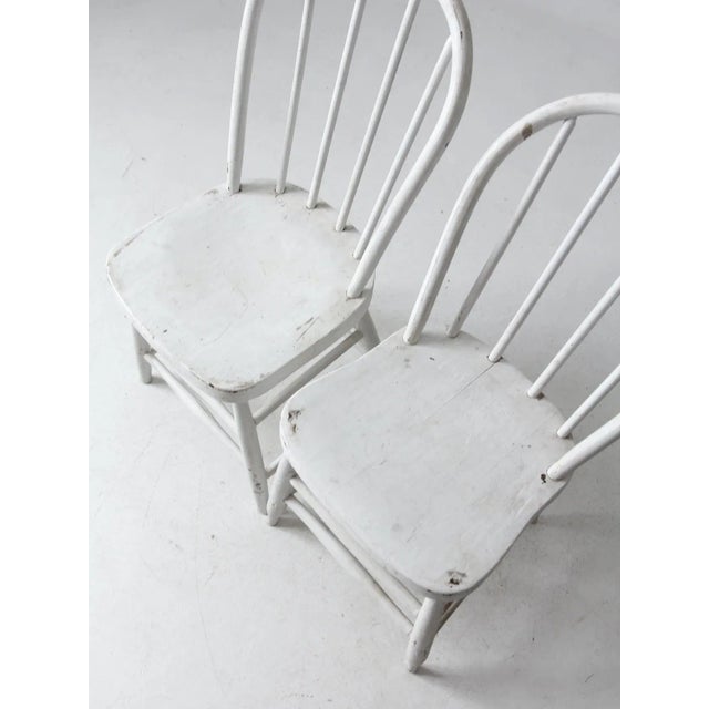 This is a pair of antique painted spindle back chairs. The rustic Windsor style farmhouse chairs features charmingly worn...