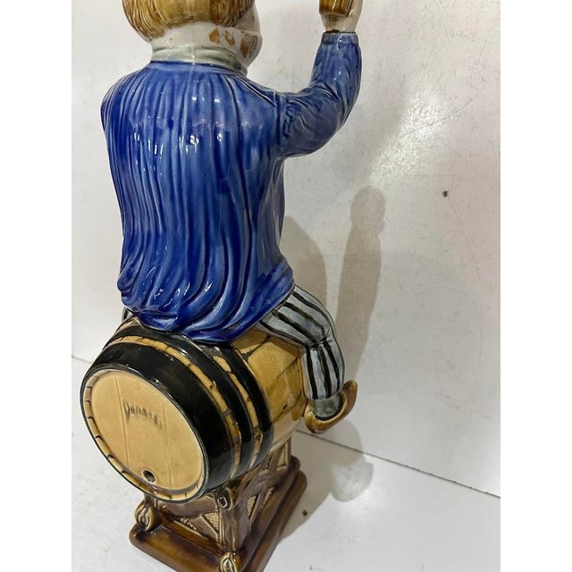 Polychrome earthenware fountain Decorated with a man seated on a barrel Wear and losses, see photos H 54 x W 23 x D 22 cm...