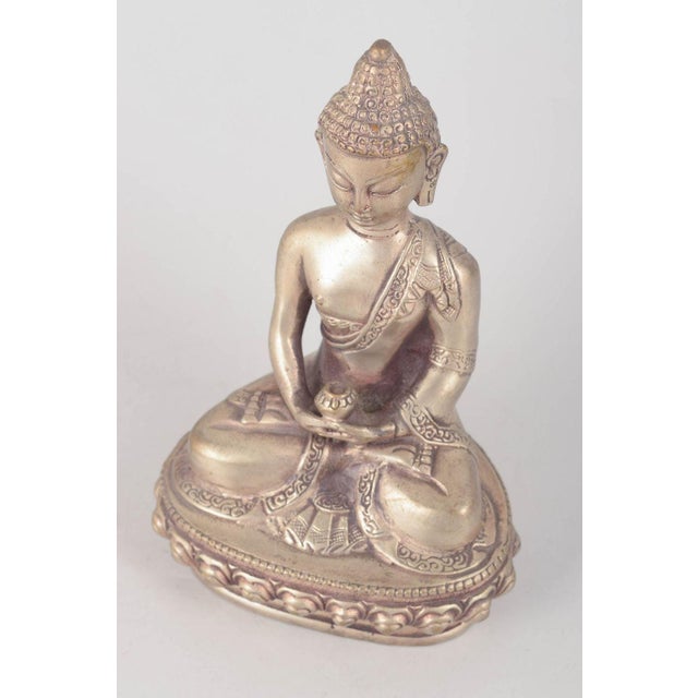 Silver-plated metal Buddha figure. Seated Buddha figure executed in silver-plated metal with a meditative pose, detailed...