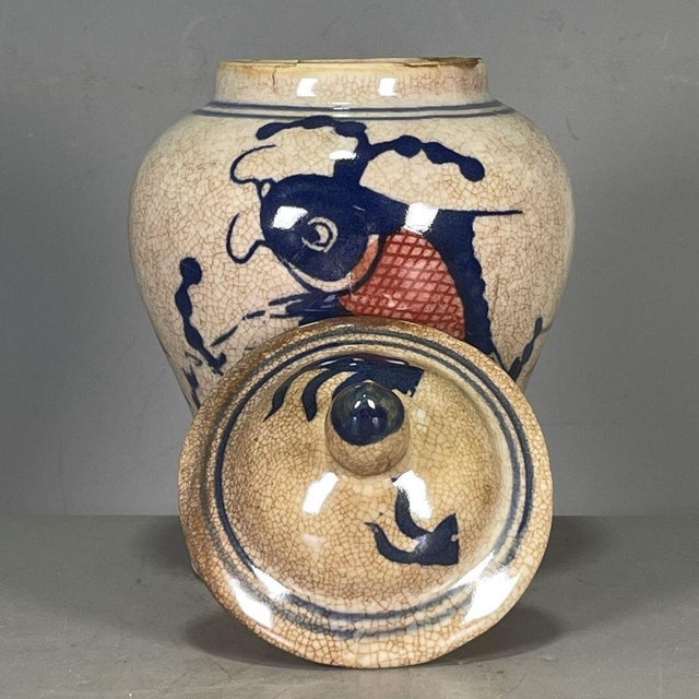 This lovely lidded ginger jar features a classic crackle glaze cream body adorned with a hand-painted koi carp design in...