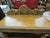 An impressive traditional wood console table featuring elaborate carved detailing and a substantial architectural design....