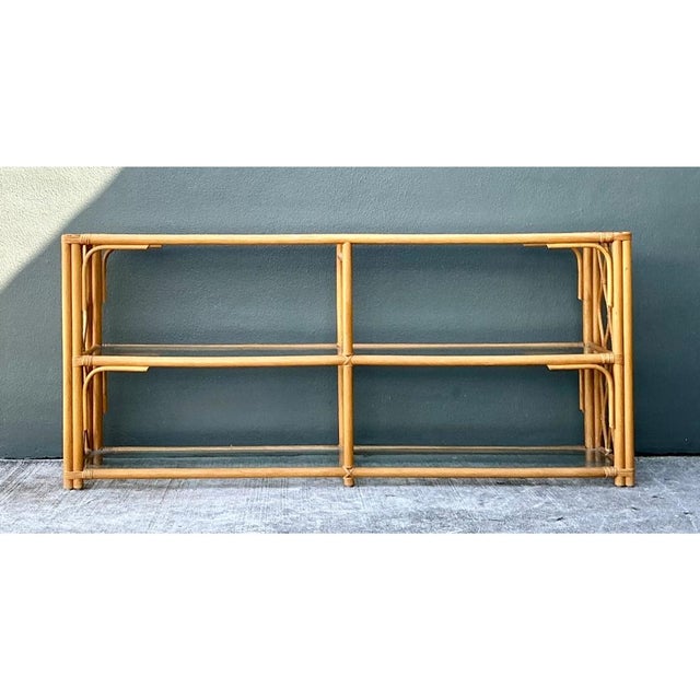 This console table pairs the natural warmth of rattan with the clean transparency of glass across three open tiers,...