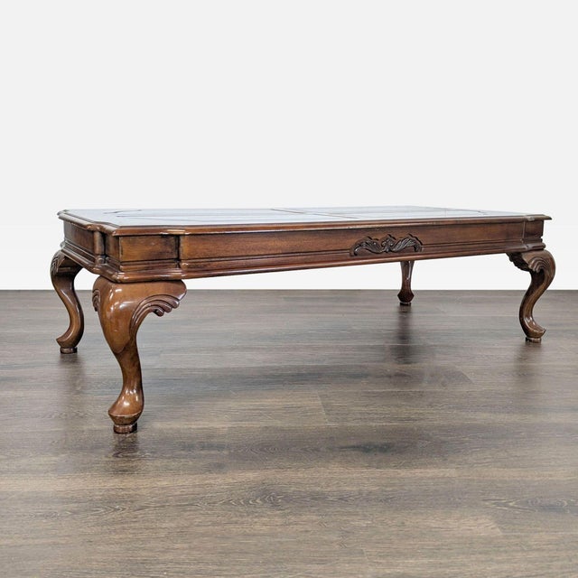 Beveled glass inserts on top with burlwood surround. Table rests on cabriole legs. Dimensions (in): 53W x 26D x 16H.