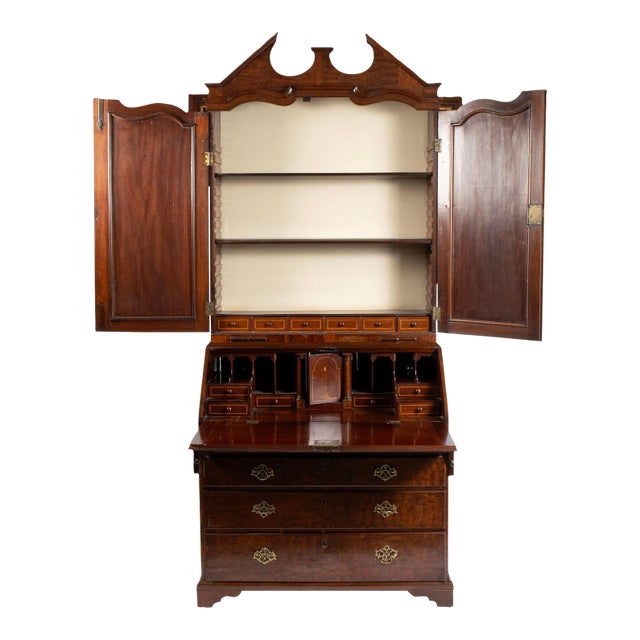 English, circa 1800, plum pudding mahogany. Top member with architectural crest over the pair of panel doors covering the...
