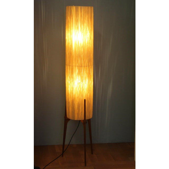 A unique Danish floor lamp on a three-legged teak base. The raffia shade creates a very interesting play of light through...