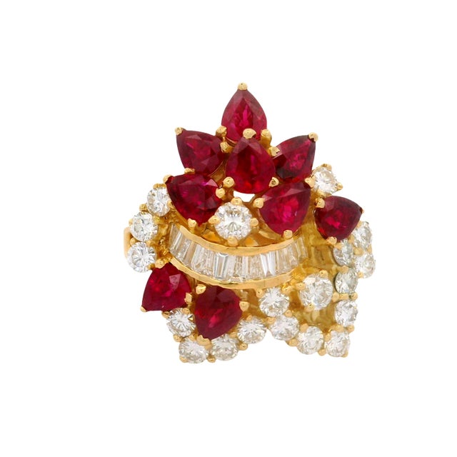 A captivating cluster ring featuring 3.68 carats of pear-cut red rubies. The vibrant rubies are complemented by 1.74...