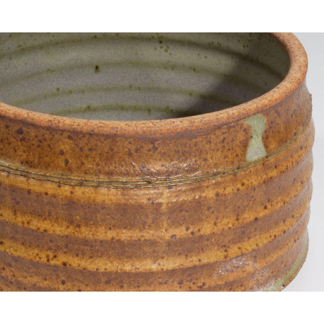 A studio pottery lidded vessel by American artist Dee Schaad. Signed “Schaad” to the underside, the vessel is glazed in a...