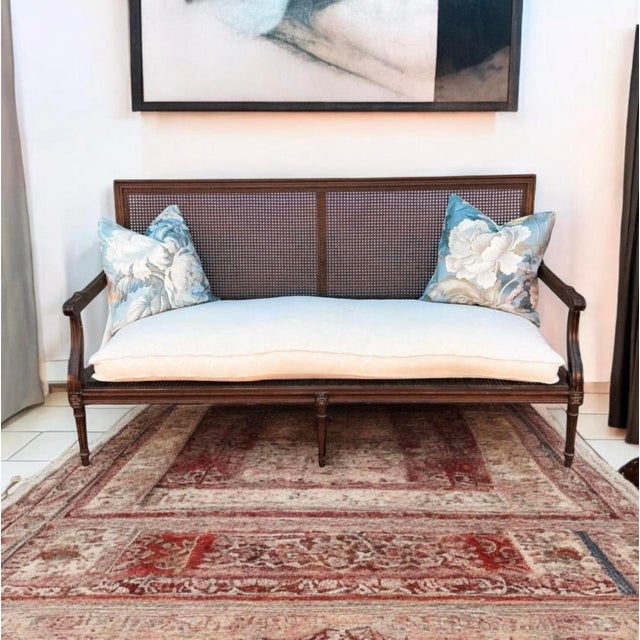 This is an early 20th century French Louis XIV settee. Both the seat and back are caned. The cushion is down and is about...