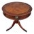 This 1940s round mahogany side table features a tooled leather top with elegant gold detailing. A decorative brass handle...