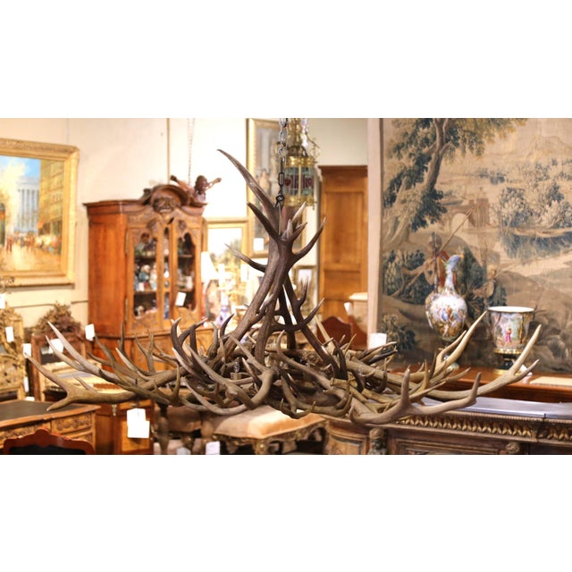 Impressive in scale and rustic character, this large vintage antler chandelier makes a striking statement in a spacious...