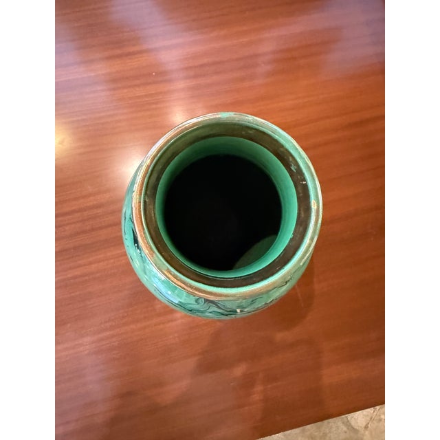 Italian decorative art glass vase from the 1970s, featuring a rich emerald-green body animated by fluid black marbled...