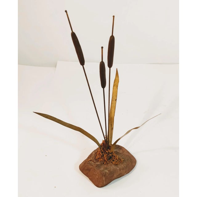 **Mid-Century Modern Metal and Rock Cattail Sculpture** This beautiful sculpture features a set of three cattails with...