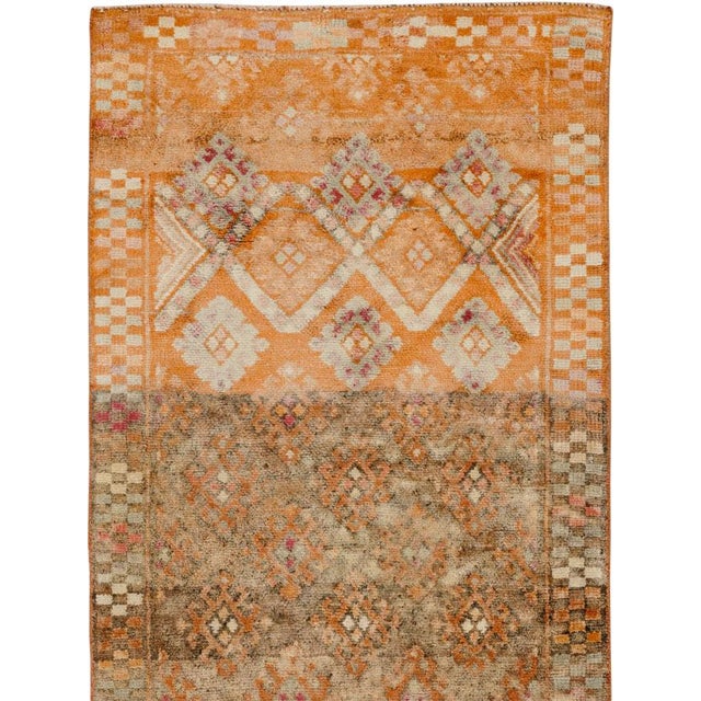 This mid-20th-century Turkish Anatolian runner presents an animated allover arrangement of small geometric motifs across a...