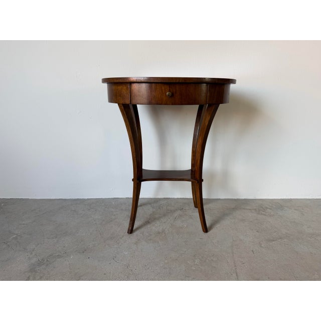 Elegant vintage Italian side table or nightstand featuring a refined oval top, a single drawer with original brass pull,...