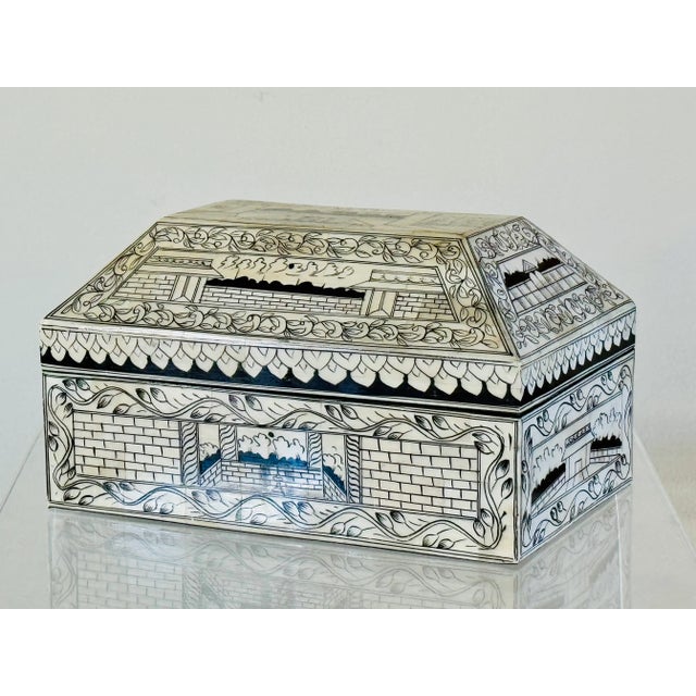 A decorated camel bone box. The faceted lid is hinged and opens to a black velvet lined interior. Traditional workmanship...