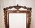 An antique neo-classical mirror made of mahogany wood. Embellishments of gold gilt urn at top, leaves from top to sides...
