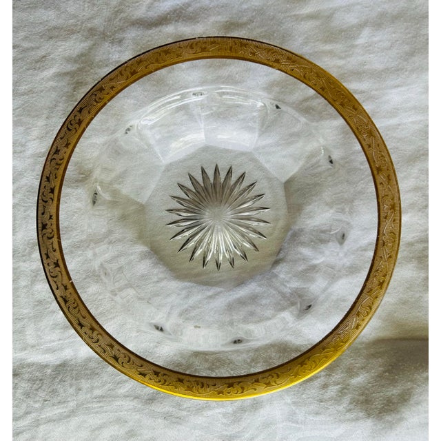 vintage collectible glass dish, featuring a gold-gilded rim and a starburst or ray pattern cut into the base. The bowl has...