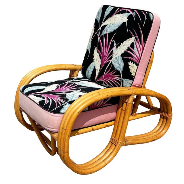 This beautifully restored Post War Mid-Century 3/4 round pretzel-arm rattan lounge chair, it features sculptural three-...