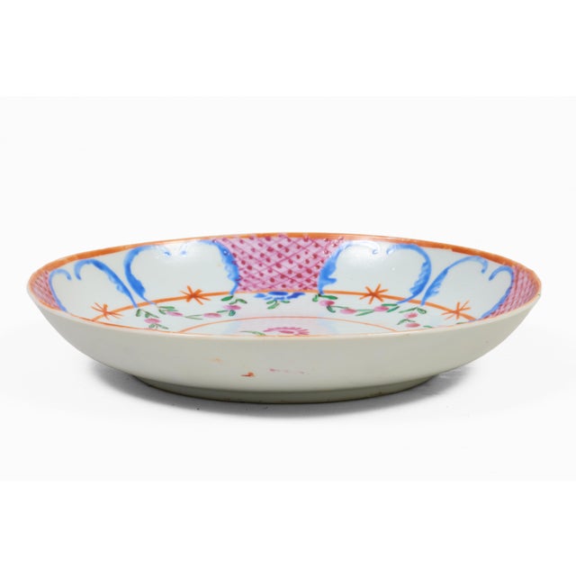 This Chinese Export porcelain plate is done in the Famille Rose palette, the central medallion is of two pink flowers and...