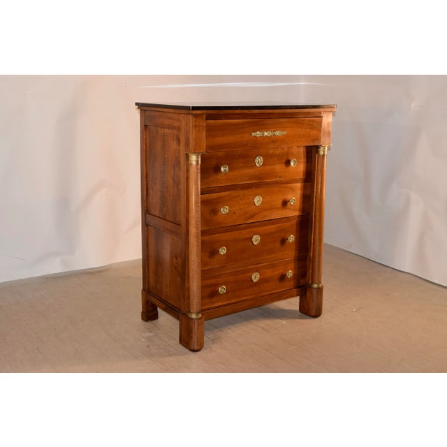 Early 19th century French tall chest of drawers with a black marble top, made from walnut. The case is lovely and has...
