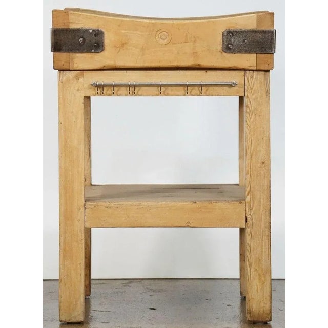 A handsome two-tiered butcher's chopping block on stand or table of pine and beech wood from England, featuring a large,...