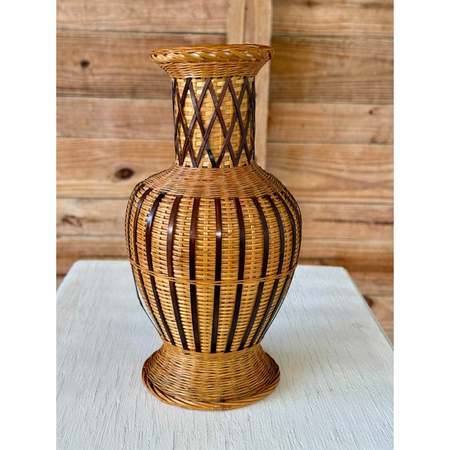 A beautiful handwoven rattan vase with a ceramic interior, combining organic craftsmanship with functional design. The...