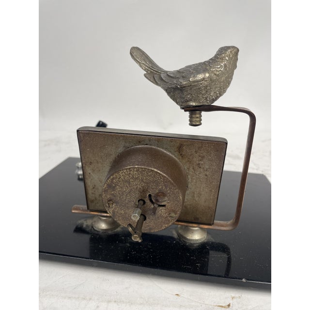 Beautiful pen holder with 1920s Liberty clock, decorated with a metal bird, glossy black glass base. Excellent furnishing...