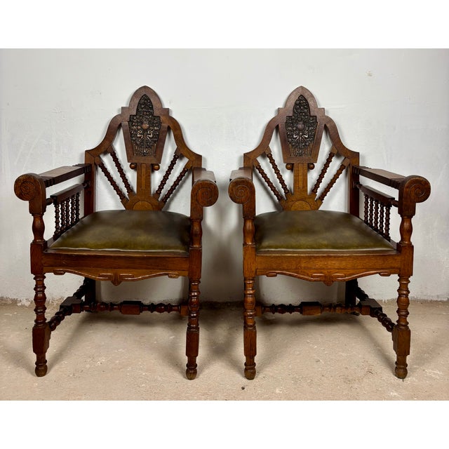 Striking pair of early 20th century Spanish armchairs crafted in solid oak with richly carved details and strong...