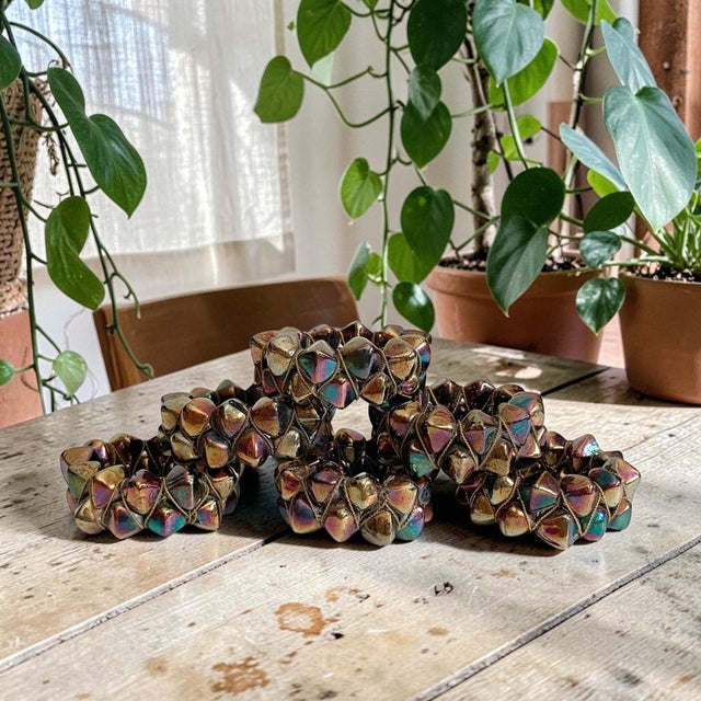 Elevate your dining experience with these Vintage Geometric Spiked Napkin Rings, adorned with iridescent, multi-toned...