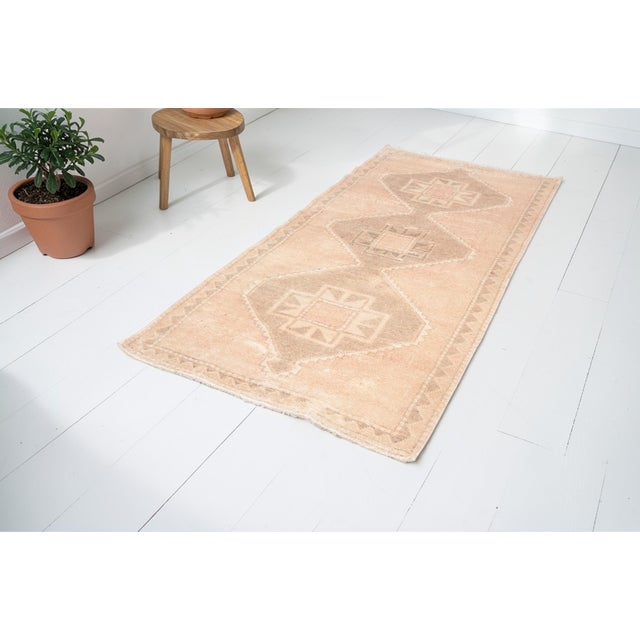 This is a vintage Turkish Oushak rug from the Mid 20th Century. The piece was hand-knotted.