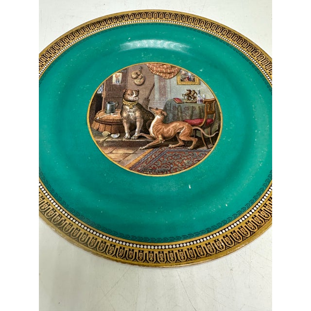 This is a late 19th-century decorative cabinet plate with a richly colored turquoise ground and an ornate gilt border...