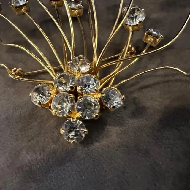 Make a sparkling statement with this exquisite vintage brooch from the 1970s by 6 Donna, a true example of Italian costume...