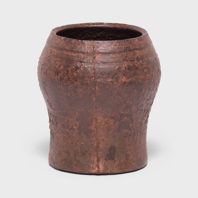 Cast in iron with a raised floral design, this vintage mortar was originally used in a traditional Qing-dynasty apothecary...