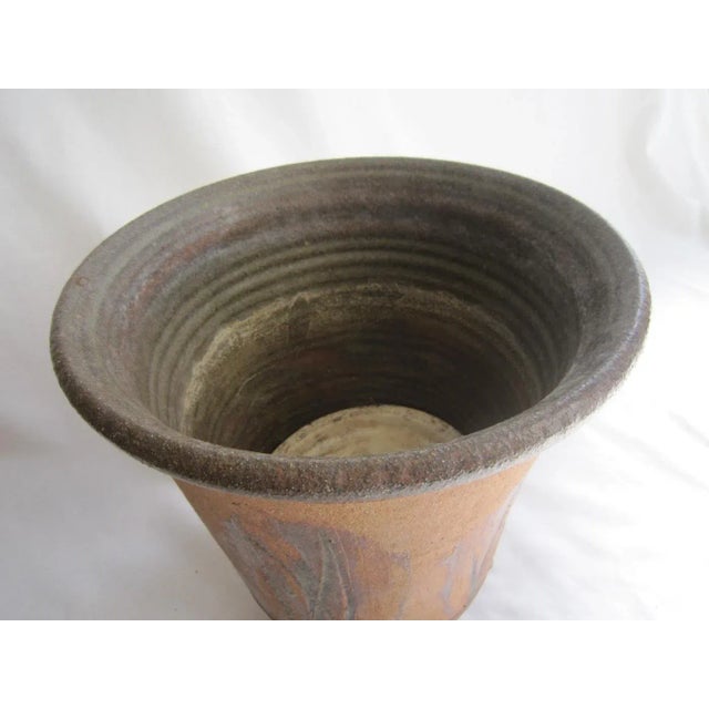 Terra cotta planter inscribed with Cattail design on all sides. Artisan designed. It measures 12"H x 13.5"D and is in...