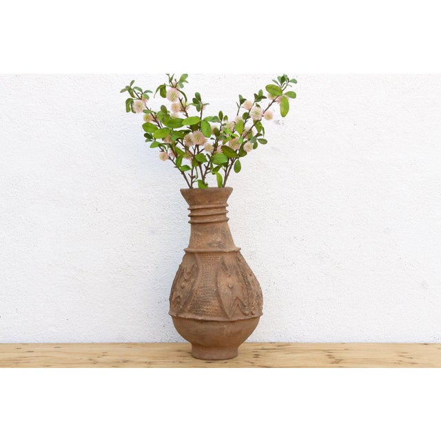 This 20-inch tall vessel is an authentic piece of hand-coiled pottery from the Nupe people of central Nigeria. The Nupe...