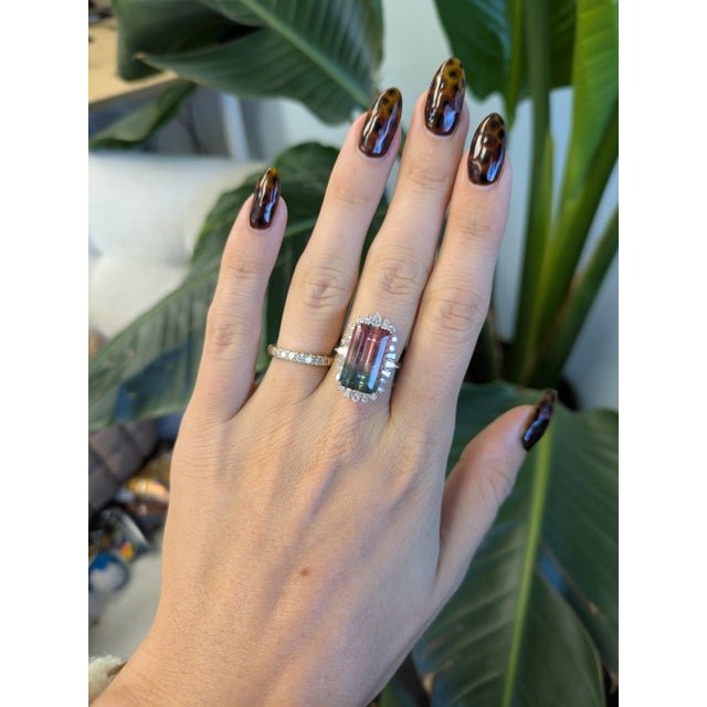 A dramatic 10.07-carat bi-color tourmaline blends two natural hues in a single emerald-cut stone, set in solid two-tone...