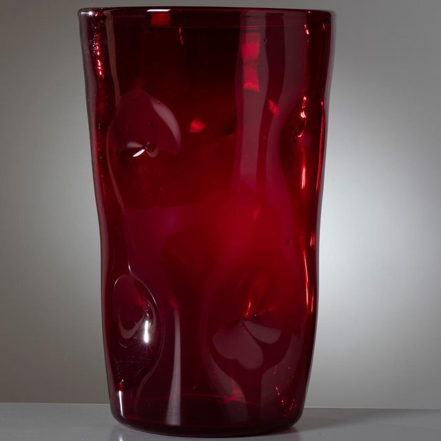 A stunning and rare Empoli glass vase, dating to the 1950s. This piece stands out for its vibrant ruby red coloration, a...