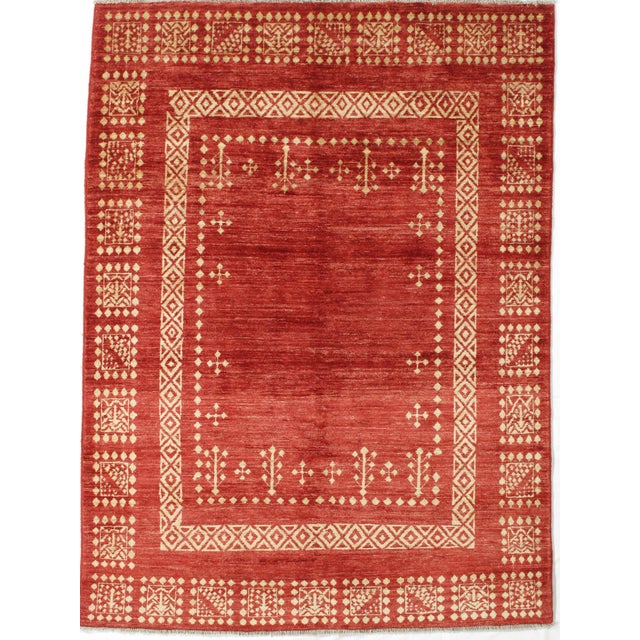 Vintage Hand-knotted Persian Gabbeh rug featuring a rich red field framed by ivory geometric borders with repeating tribal...