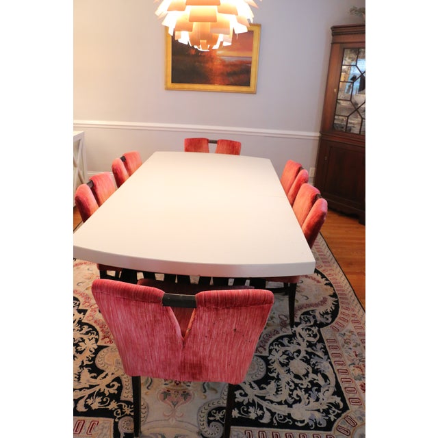 Paul Frankl classic cork top table with walnut base. Two arm chairs in dark red velvet and six side chairs with two...