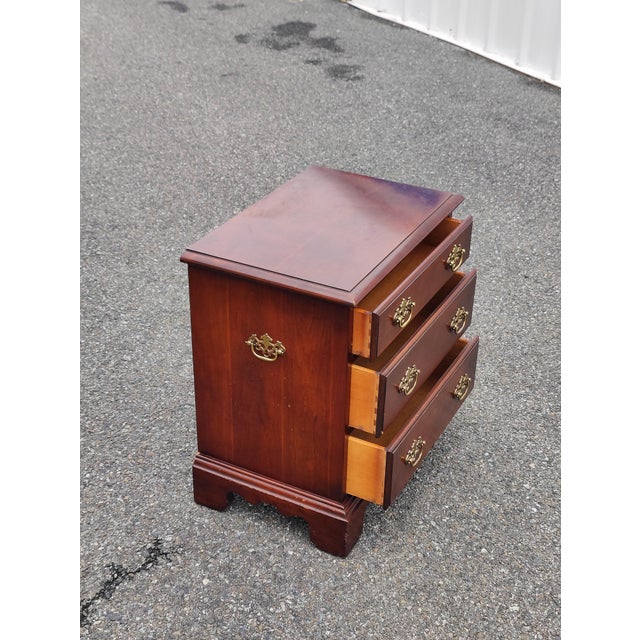 This three-drawer chest of drawers is a Chippendale-style piece with brass hardware and bracket feet. It also has...