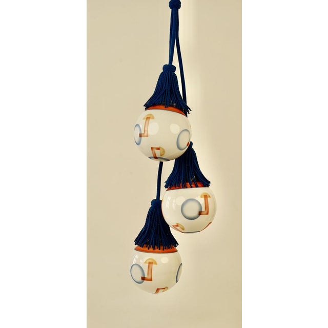 A beautiful pendant light made in austria in the 1920's. It features three opaline glass balls, decorated with geometric...