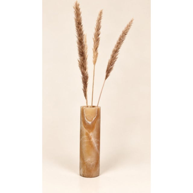 Cylindrical vase carved from a single block of natural onyx, carefully polished to reveal the characteristic translucency...