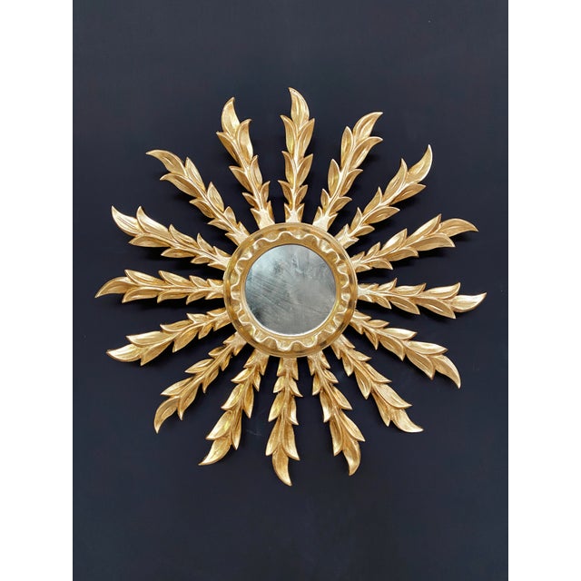 Vintage handcrafted golden sunburst mirror. Composed of a unique row of 16 gilded wooden rays. Measurements: - Total...