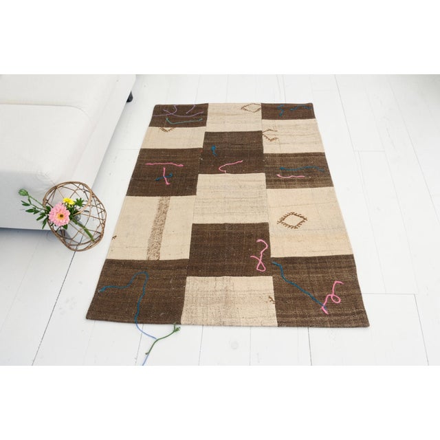 This is a vintage Turkish Oushak rug from the Mid 20th Century. The piece was hand-knotted.