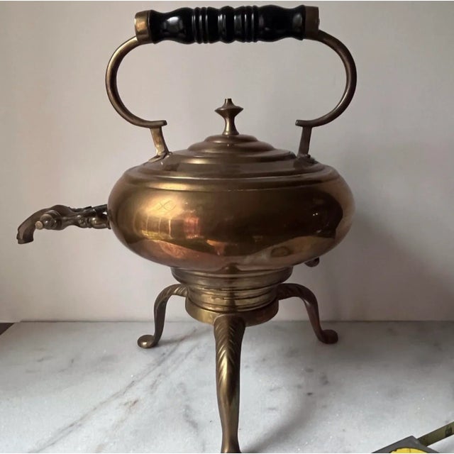 This is an antique brass tea kettle on a stand, also known as a samovar. These types of kettles were used to keep water...