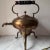 This is an antique brass tea kettle on a stand, also known as a samovar. These types of kettles were used to keep water...