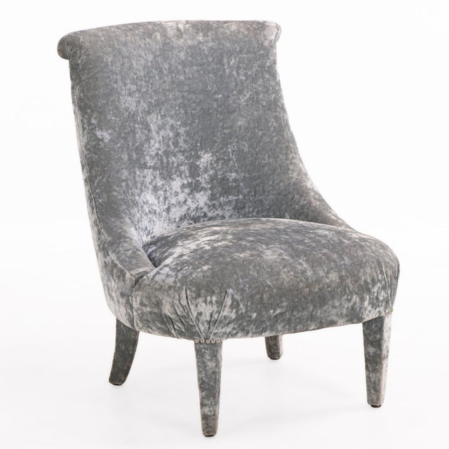 Upholstered in soft silver-gray velvet, each chair features a gracefully curved high back with a rolled crest, gently...